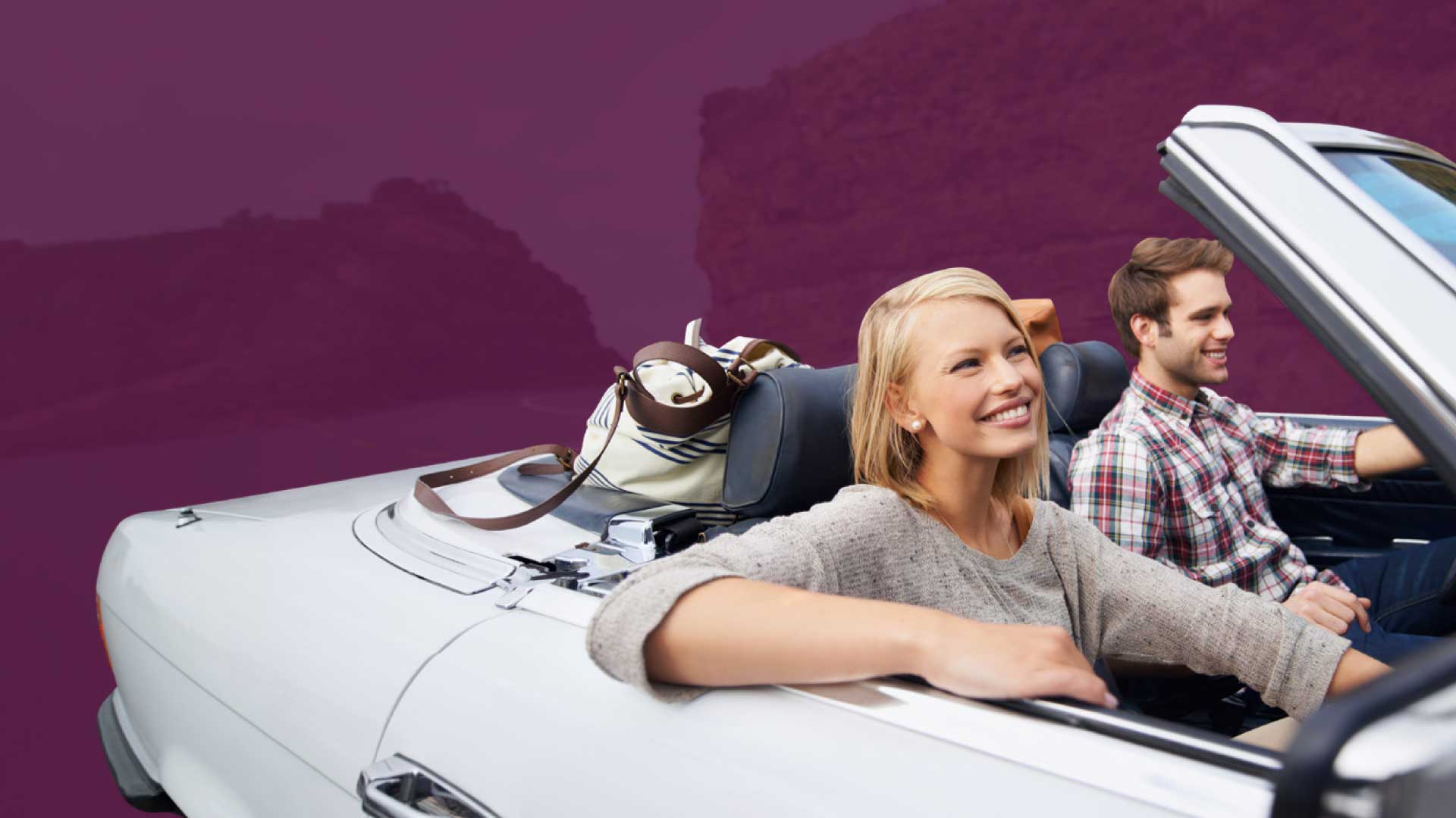 young_couple_riding_in_convertible_car_smiling
